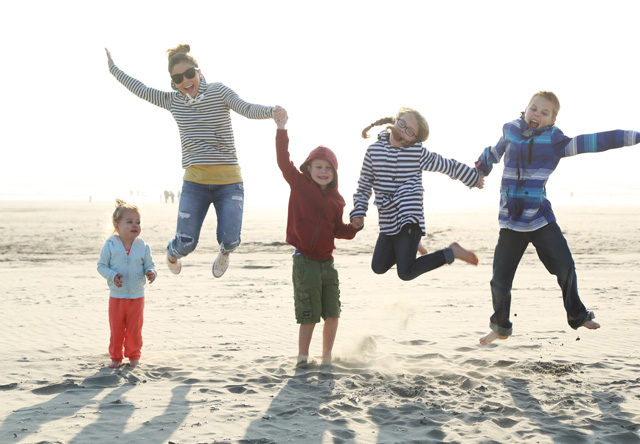 jumping on the beach with littles