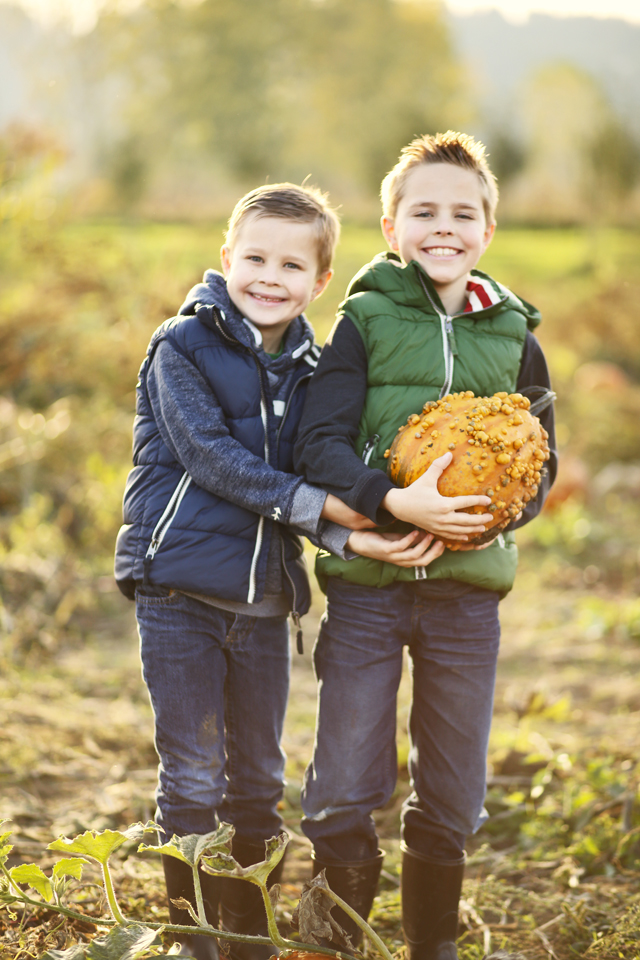 cute boys in a pumpkin patch puffer vests