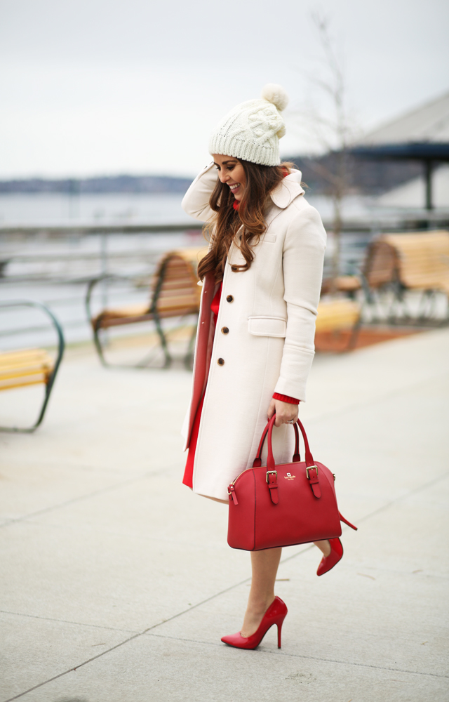 white coat, white beanie, red bag
